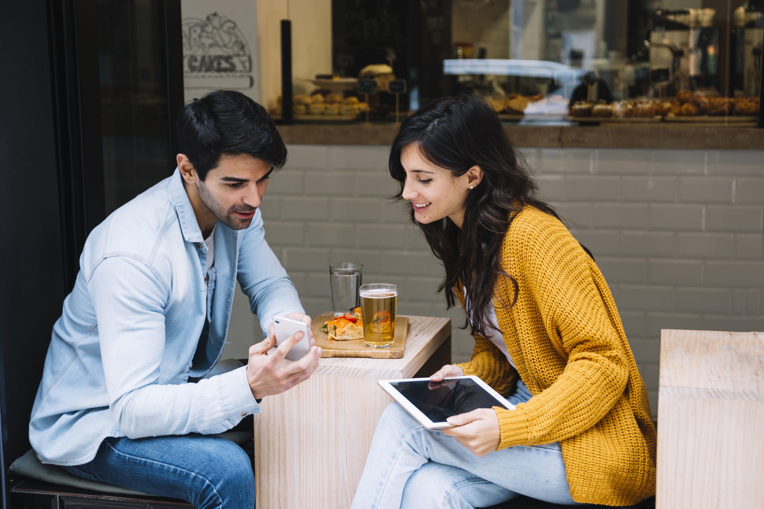 couple-cafe-looking-smartphone-screen