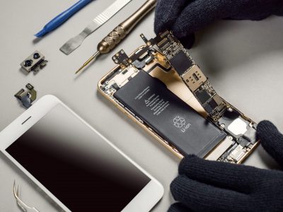 Technician repairing broken smartphone on desk